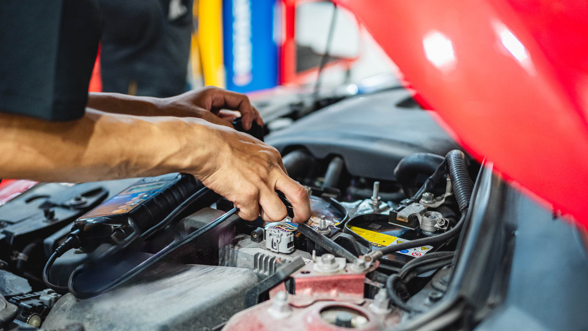 A technician in Abilene, TX, inspecting a car bumper for hidden damage and tire rubbing after a minor collision.